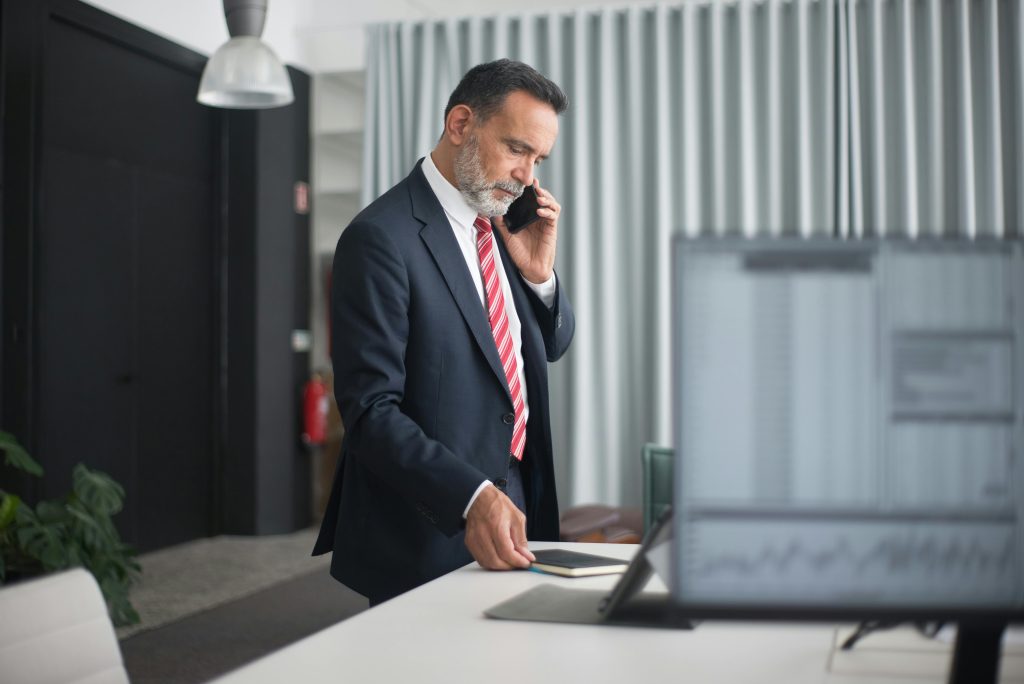 Professional man in a business suit on a phone call in a modern office setting.